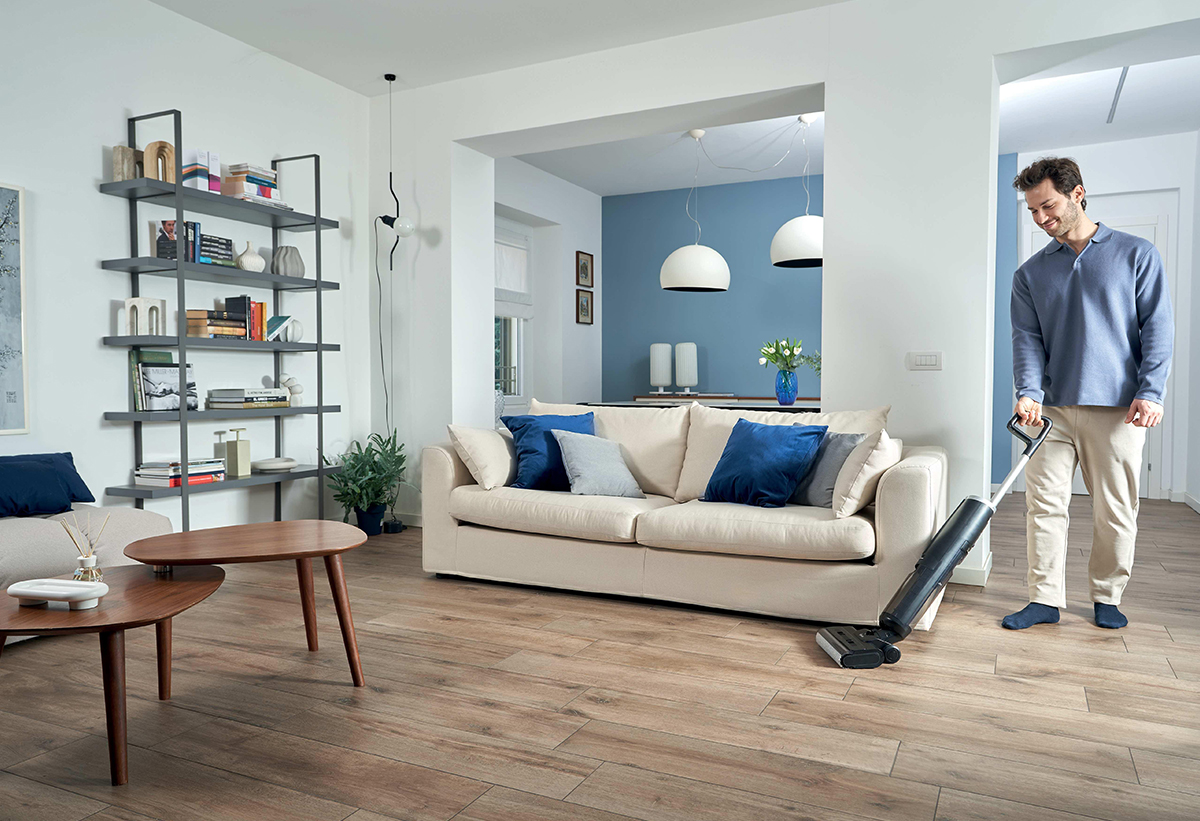 Απεικονίζεται άνδρας να καθαρίζει στο σαλόνι.